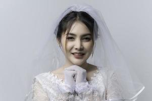 ritratto di asiatico donna indossare sposa con fiore su bianca sfondo, matrimonio concetto foto