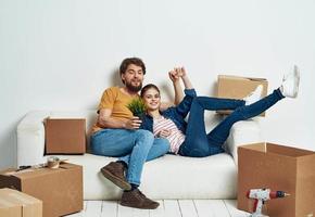 sposato coppia nel nuovo appartamento in movimento scatole con gioia cose foto