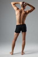 sportivo uomo nel nero pantaloncini detiene mano su testa indietro Visualizza allenarsi fitness foto