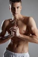 sexy atleti con gonfiato torso Tenere mani vicino il petto su grigio sfondo ritagliata Visualizza foto