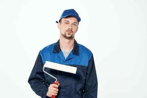 uomo nel Lavorando uniforme dipingere rullo riparazione opera foto