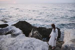 donna nel bianca cappotto pietre natura tempo metereologico oceano la libertà foto