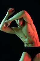 maschio atleta su un' buio sfondo in posa e mostrando muscoli su il addome bodybuilder fitness foto