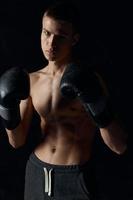 gli sport tipo su un' nero sfondo nel boxe guanti gonfiato torso ritagliata Visualizza modello foto