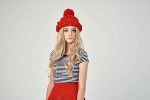 bellissimo donna nel alla moda Abiti rosso cappello leggero sfondo foto