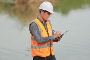 ambientale ingegneri opera a acqua fonte per dai un'occhiata per contaminanti nel acqua fonti e analizzando acqua test risultati per riutilizzare.mondo ambiente giorno concetto. foto