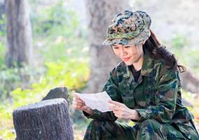 ritratto di una donna soldato seduta felicemente leggendo una lettera foto
