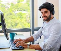 uomo d'affari seduto in ufficio e sorridente felicemente foto