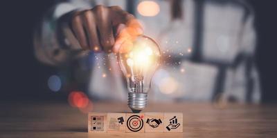 umano mano puntamento a un' leggero lampadina, trovare nuovo soluzioni per risolvere attività commerciale problemi, innovazione e cervello energia a partire dal brainstorming, ricerca creatività e ispirazione, successo attività commerciale idee foto