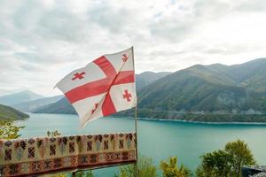 bandiera georgiana con uno sfondo di paesaggio di montagna foto