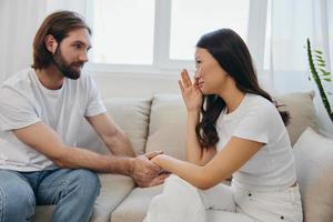 un asiatico donna è triste e pianto con sua maschio amico a casa. fatica e malinteso nel un' relazione fra Due persone e supporto ogni altri mentale e emotivo benessere foto