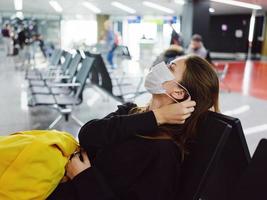 viaggiatori medico maschera aeroporto in attesa per volo giallo zaino foto