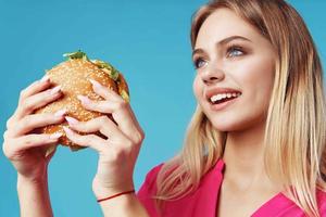 carino bionda nel rosa camicia Hamburger merenda divertimento foto