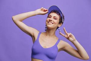 moda donna nel luminosa viola abbigliamento sportivo ritratto sorridente e guardare a telecamera su viola sfondo e sorridente foto