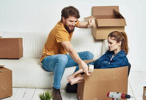 famiglia giovane coppia su il divano divertimento in movimento scatole con cose foto