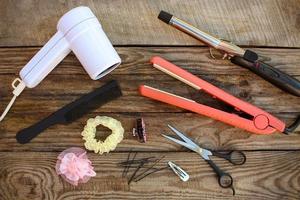 capelli Accessori capelli asciugatrice, arricciatura ferro da stiro, capelli ferro da stiro, pettine, forbici, capelli clip su il vecchio di legno sfondo. tonica Immagine foto