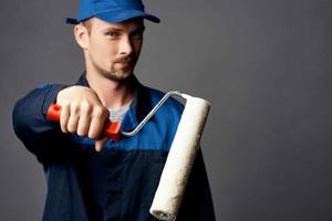 uomo nel Lavorando uniforme pittore riparazione professionale interno foto