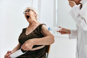 anziano donna a il medico appuntamento siringa iniezione ospedale foto