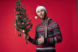uomo con Natale albero giocattoli vacanza decorazione rosso sfondo foto
