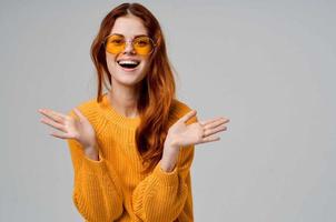 bella donna nel un' giallo maglione moda bicchieri leggero sfondo foto