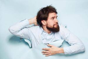 un' uomo nel un' camicia sbircia su a partire dal dietro a il parete di un' carriera opera emozioni foto