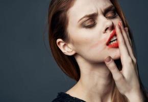 affascinante donna sbavature rossetto tutti al di sopra di sua viso foto