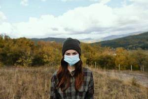viaggiatore nel un' medico maschera e un' rigoroso Guarda a natura autunno montagne foto