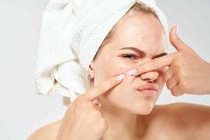 donna con spoglio le spalle spreme su brufoli su dermatologia malcontento viso foto