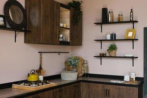 interno design di il cucina-pranzo camera nel un' moderno scandinavo stile con buio di legno mobilia e utensili da cucina foto