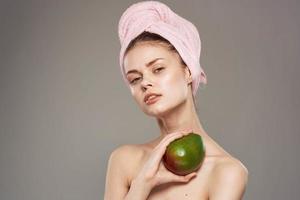 bella donna con rosa asciugamano su testa Mango spoglio le spalle vitamine foto