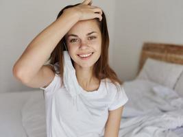 bella donna con medico maschera su sua viso tocchi sua testa con sua mano e sorrisi foto