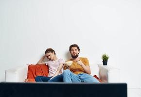 uomo e donna su il divano Guardando tv fiore in vaso foto