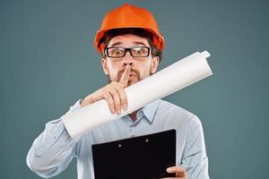 uomo lavoratore con documenti nel mani indossare bicchieri arancia casco sicurezza professionale foto