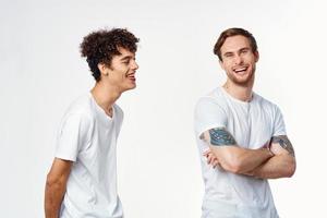 Due allegro amici nel bianca magliette In piedi lato di lato ritagliata Visualizza foto
