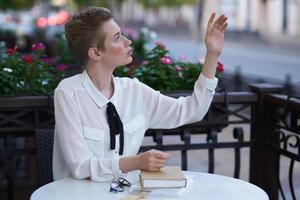 femmina nel un' estate bar lettura camminare nel il fresco aria formazione scolastica foto