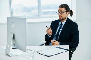 ufficio lavoratore a il scrivania con bicchieri opera tecnologie foto