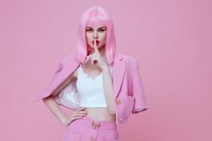 bellezza moda donna nel un' rosa completo da uomo Esprimere a gesti con il suo mani emozioni divertimento colore sfondo inalterato foto