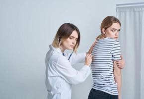 medico donna nel medico toga con stetoscopio ascolta per del paziente cuore foto