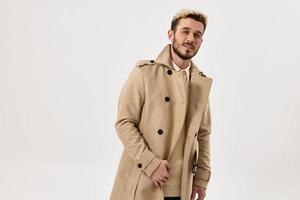 uomo beige cappotto mani su il cintura Guarda avanti alla moda acconciatura foto