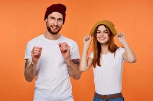 divertente uomo e donna nel magliette gioventù capi di abbigliamento arancia sfondo foto