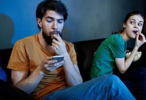 emotivo donna e uomo su il divano con Popcorn Guardando tv foto