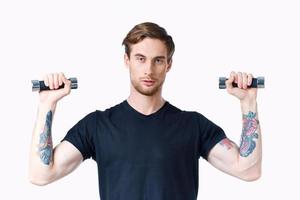 uomo con pompato su braccio muscoli fitness allenarsi nero maglietta manubri foto