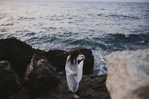 donna con bagnato capelli vestiti all'aperto spiaggia oceano paesaggio marino foto