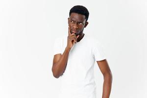 attraente giovane uomo di africano aspetto nel maglietta Esprimere a gesti con il suo mani foto