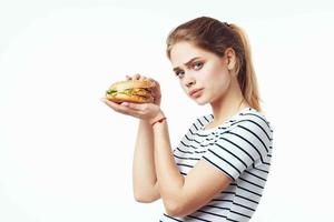 donna nel a strisce maglietta veloce cibo merenda Rifiuto cibo foto