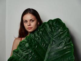 bella donna con pulito pelle e verde palma foglia leggero sfondo modello foto