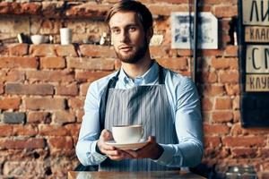 maschio Cameriere grembiule caffè tazza professionale barista opera foto