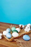 colorato uova su di legno vassoio verbena decorazione blu sfondo vacanza foto
