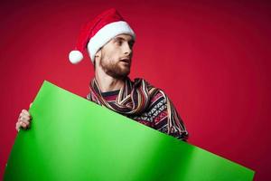 allegro uomo nel un' Natale cappello con verde modello rosso sfondo foto