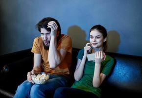 un' uomo e un' donna siamo Guardando tv nel il sera in casa foto